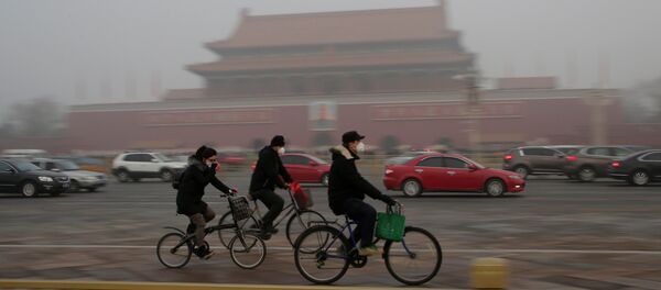 People wearing masks cycle past Tiananmen Gate during the smog after a red alert was issued for heavy air pollution in Beijing, China, December 20, 2016. People wearing masks cycle past Tiananmen Gate during the smog after a red alert was issued for heavy air pollution in Beijing, China, December 20, 2016. - Sputnik International