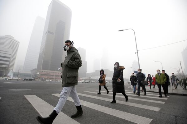 A man wearing a respiratory protection mask walks toward an office building during the smog after a red alert was issued for heavy air pollution in Beijing's central business district, China, December 21, 2016 A man wearing a respiratory protection mask walks toward an office building during the smog after a red alert was issued for heavy air pollution in Beijing's central business district, China, December 21, 2016 - Sputnik International