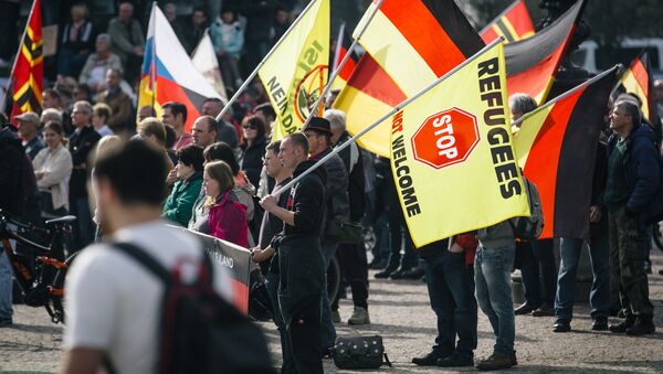 Supporters of the anti-immigrant Pegida movement (Patriotic Europeans Against the Islamisation of the Occident) mark the second year of existence as they demonstrate in Dresden, eastern Germany, on October 2016. - Sputnik International