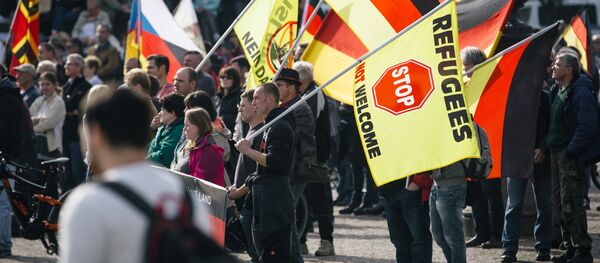 Supporters of the anti-immigrant Pegida movement (Patriotic Europeans Against the Islamisation of the Occident) mark the second year of existence as they demonstrate in Dresden, eastern Germany, on October 2016. - Sputnik International