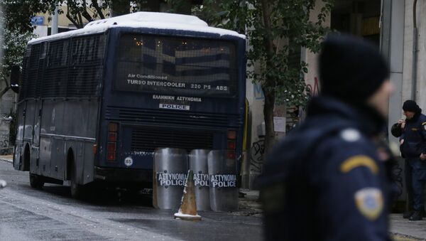 Policemen stand outside the Pan-Hellenic Socialist Movement (PASOK) offices after a gunman opened fire at the bus, left, in Athens, on Tuesday, Jan. 10, 2017. - Sputnik International