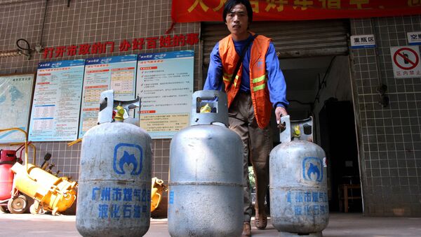 A worker delivers cylinders of liquefied petroleum gas (LPG) at a LPG service station in Guangzhou, southern China's Guangdong province. (File) - Sputnik International
