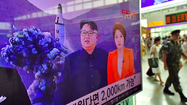 A South Korean soldier (R) walks past a television screen reporting news of North Korea's latest submarine-launched ballistic missile test at a railway station in Seoul on August 25, 2016 - Sputnik International