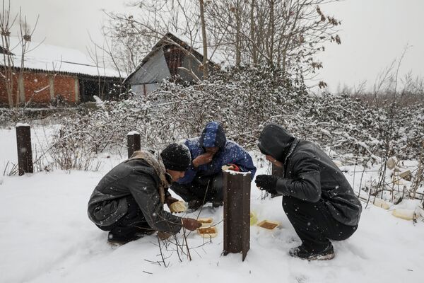 Migrants eat free food during a snowfall outside a derelict customs warehouse in Belgrade, Serbia January 9, 2017 Migrants eat free food during a snowfall outside a derelict customs warehouse in Belgrade, Serbia January 9, 2017 - Sputnik International