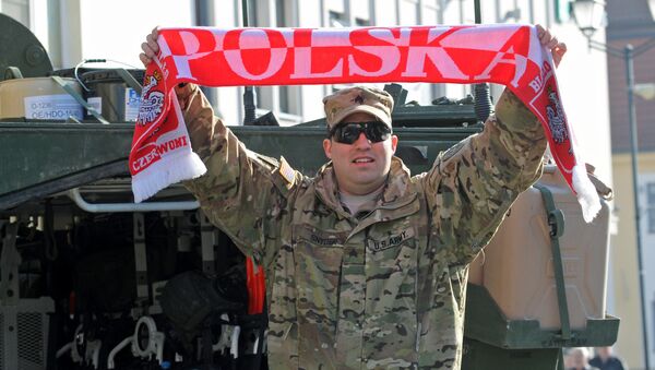 Sgt Robert Snyder from the 3rd Squadron of the 2nd Cavalry Regiment waves a scarf with the inscription Poland as a group of Stryker armored vehicles stop on the Kosciuszko Market Square to meet residents in Bialystok, Poland, Tuesday, March 24, 2015 - Sputnik International