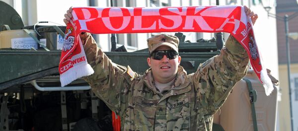 Sgt Robert Snyder from the 3rd Squadron of the 2nd Cavalry Regiment waves a scarf with the inscription Poland as a group of Stryker armored vehicles stop on the Kosciuszko Market Square to meet residents in Bialystok, Poland, Tuesday, March 24, 2015 Sgt Robert Snyder from the 3rd Squadron of the 2nd Cavalry Regiment waves a scarf with the inscription Poland as a group of Stryker armored vehicles stop on the Kosciuszko Market Square to meet residents in Bialystok, Poland, Tuesday, March 24, 2015 - Sputnik International