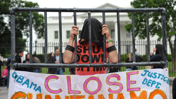 A hooded demonstrator is seen at a protest calling for the closure of the Guantanamo Bay detention facility in front of the White House on May 18, 2013 in Washington, DC. - Sputnik International