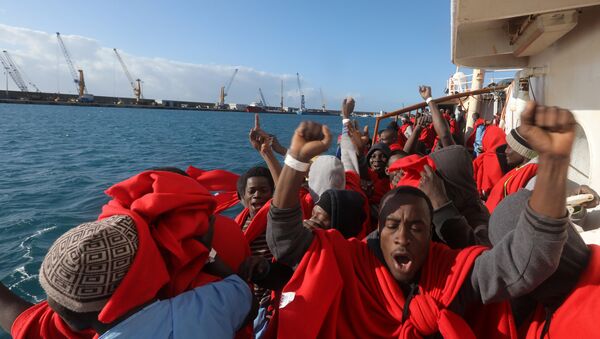 Migrants celebrate on board the former fishing trawler Golfo Azzurro as they arrive at the port of Pozzallo in Sicily, two days after they were rescued by the Spanish NGO Proactiva Open Arms after the raft they were on drifted out of control in the central Mediterranean Sea, January 4, 2017 - Sputnik International