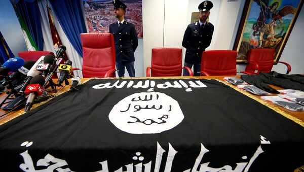 Police officers stand next to a black Islamic State flag that was seized in a raid, at a news conference held at the police headquarters in Rome, Italy, January 10, 2017 - Sputnik International