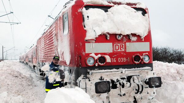 A worker shovels snow at a railway train that is stocked in the snow near Anklam, northern Germany (File) - Sputnik International