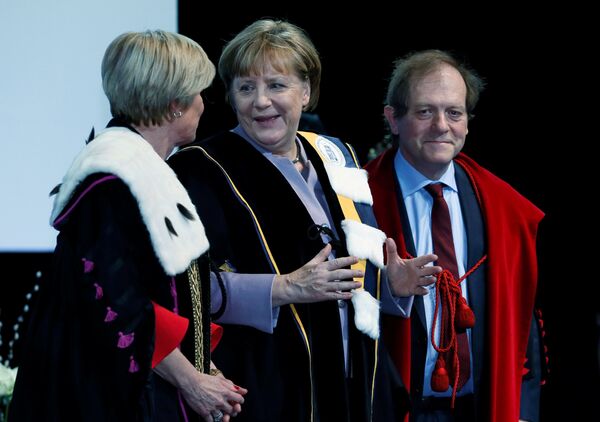 German Chancellor Angela Merkel (C) talks to Rector Anne De Paepe (L) of Belgian UGent university during a ceremony to receive a degree Honoris Causa, or honorary doctorate from the Belgian universities of KU Leuven and UGent in Brussels, Belgium January 12, 2017. German Chancellor Angela Merkel (C) talks to Rector Anne De Paepe (L) of Belgian UGent university during a ceremony to receive a degree Honoris Causa, or honorary doctorate from the Belgian universities of KU Leuven and UGent in Brussels, Belgium January 12, 2017. - Sputnik International