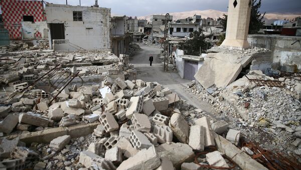 A man walks past damaged buildings in the rebel held besieged city of Douma, in the eastern Damascus suburb of Ghouta, Syria January 8, 2017 - Sputnik International