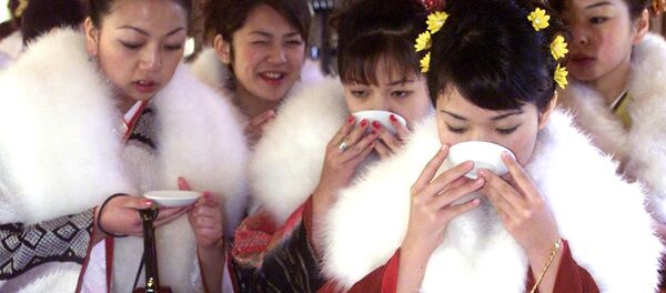 Tour bus guides clad in kimono drink sake after praying at Meiji Shrine to celebrate their coming of age in Tokyo (File) - Sputnik International