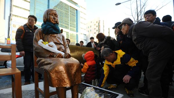A flower is laid on a statue of a girl that represents the sexual victims by the Japanese military during a rally in front of Japanese Consulate in Busan, South Korea, December 30, 2016. Picture taken December 30, 2016 - Sputnik International
