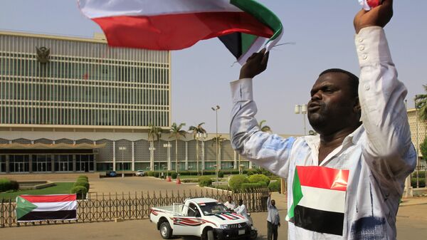 A Sudanese man waves his national flag in Khartoum on July 9, 2011 hours before South Sudan officially declares independence from the north - Sputnik International