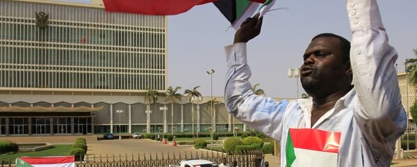 A Sudanese man waves his national flag in Khartoum on July 9, 2011 hours before South Sudan officially declares independence from the north - Sputnik International