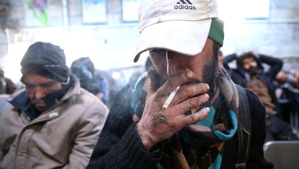 In this Tuesday, Feb. 3, 2015 photo, a drug addict smokes cigarette at drop-in center and shelter south of Tehran, Iran - Sputnik International