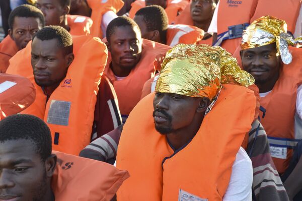 Migrants and refugees wait to be trasferred from the Topaz Responder ship run by Maltese NGO Moas and the Italian Red Cross to the Vos Hestia ship run by NGO Save the Children, on November 4, 2016, a day after a rescue operation off the Libyan coast in the Mediterranean Sea. Migrants and refugees wait to be trasferred from the Topaz Responder ship run by Maltese NGO Moas and the Italian Red Cross to the Vos Hestia ship run by NGO Save the Children, on November 4, 2016, a day after a rescue operation off the Libyan coast in the Mediterranean Sea. - Sputnik International