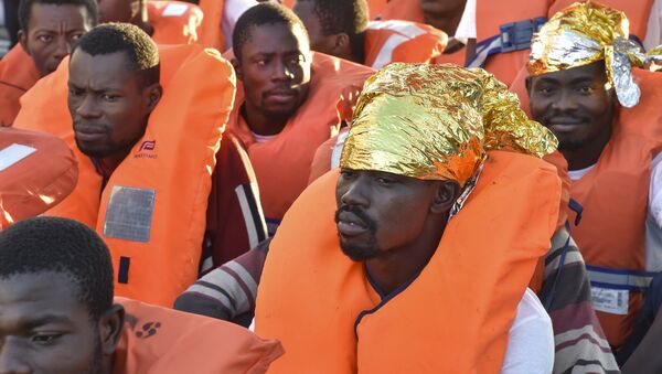Migrants and refugees wait to be trasferred from the Topaz Responder ship run by Maltese NGO Moas and the Italian Red Cross to the Vos Hestia ship run by NGO Save the Children, on November 4, 2016, a day after a rescue operation off the Libyan coast in the Mediterranean Sea. - Sputnik International
