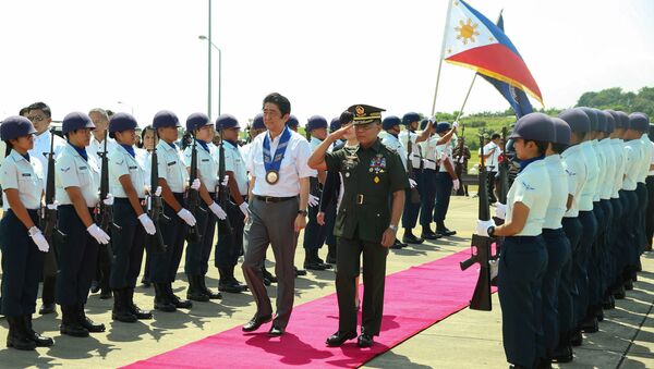 Japan's Prime Minister Shinzo Abe is accompanied by Major General Leonardo Guerrero of the Philippine Army as they walk past the guard of honour before his departure from the Francisco Bangoy International Airport in Davao City, southern Philippines January 13, 2017 - Sputnik International