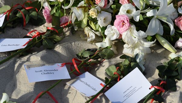 Flowers lie on the beach on June 26, 2016, during a ceremony attended by British and Tunisian officials in memory of those killed a year ago by a jihadist gunman in front of the Riu Imperial Marhaba Hotel in Port el Kantaoui, on the outskirts of Sousse south of the capital Tunis. Tourists fled in horror on June 26, 2015 as a Tunisian gunman pulled a Kalashnikov rifle from inside a furled beach umbrella and went on a shooting spree outside the five-star hotel. 30 Britons were among 38 foreign holidaymakers killed in the attack. - Sputnik International