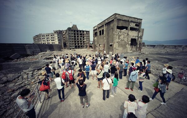 Tourists visit a part of Hashima Island, commonly known as Gunkanjima, which means “Battleship Island,” off Nagasaki, Nagasaki Prefecture, southern Japan - Sputnik International