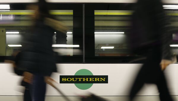 Travelers pass a train as Southern railway workers are on strike at Victoria Station in London - Sputnik International