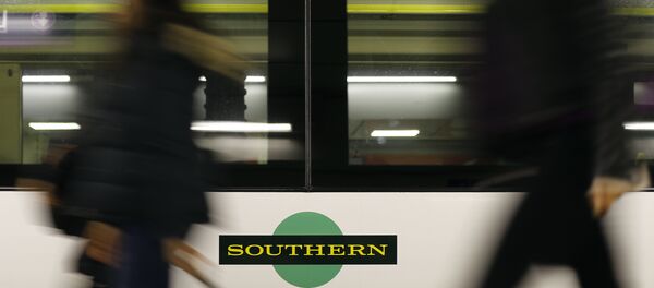Travelers pass a train as Southern railway workers are on strike at Victoria Station in London Travelers pass a train as Southern railway workers are on strike at Victoria Station in London - Sputnik International
