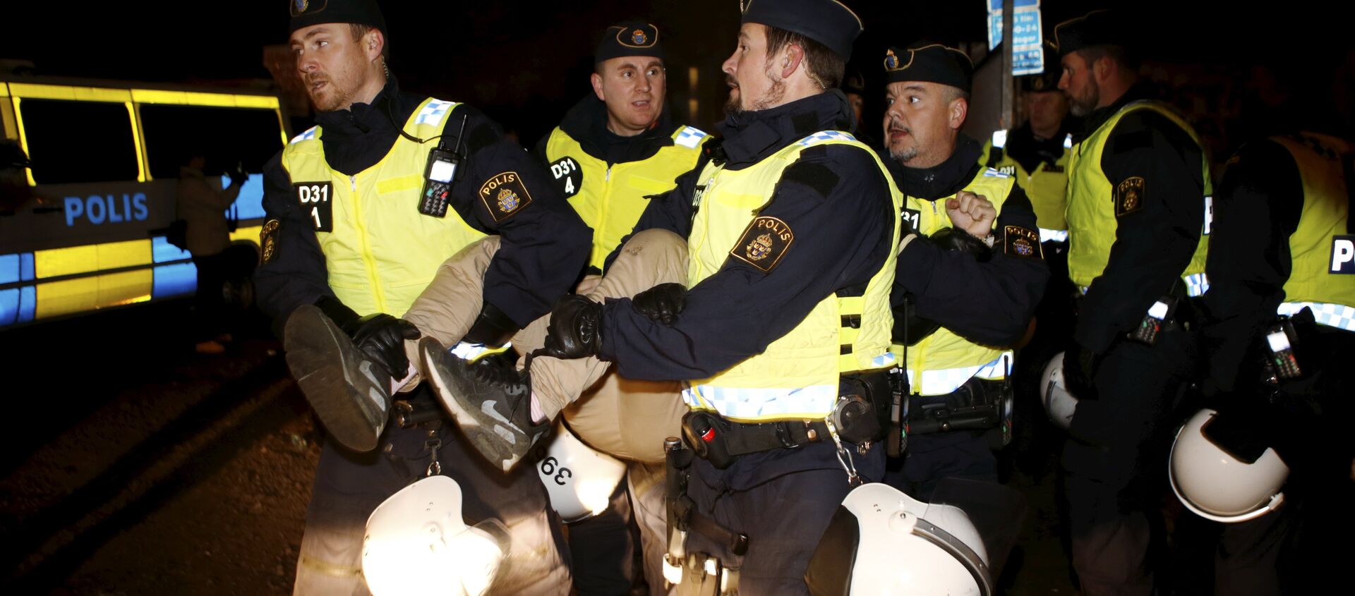 A migrant is carried out by police officers from an illegal camp set up in Malmo - Sputnik International, 1920, 06.09.2021