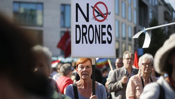 A woman holds a poster against drones during a demonstration against the upcoming visit of United States President Barack Obama in Berlin, Monday, June 17, 2013 - Sputnik International