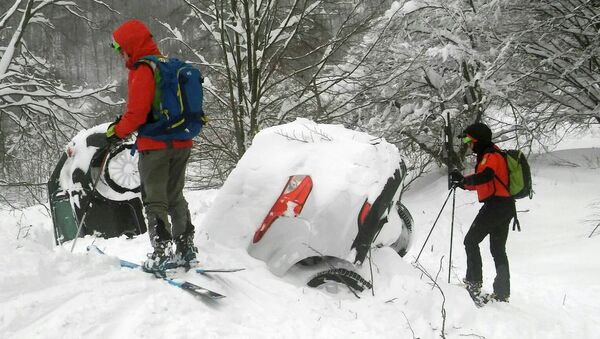 Members of Lazio's Alpine and Speleological Rescue Team are seen next to cars covered in snow in front of the Hotel Rigopiano in Farindola, central Italy, hit by an avalanche, in this January 19, 2017 handout picture provided by Lazio's Alpine and Speleological Rescue Team - Sputnik International