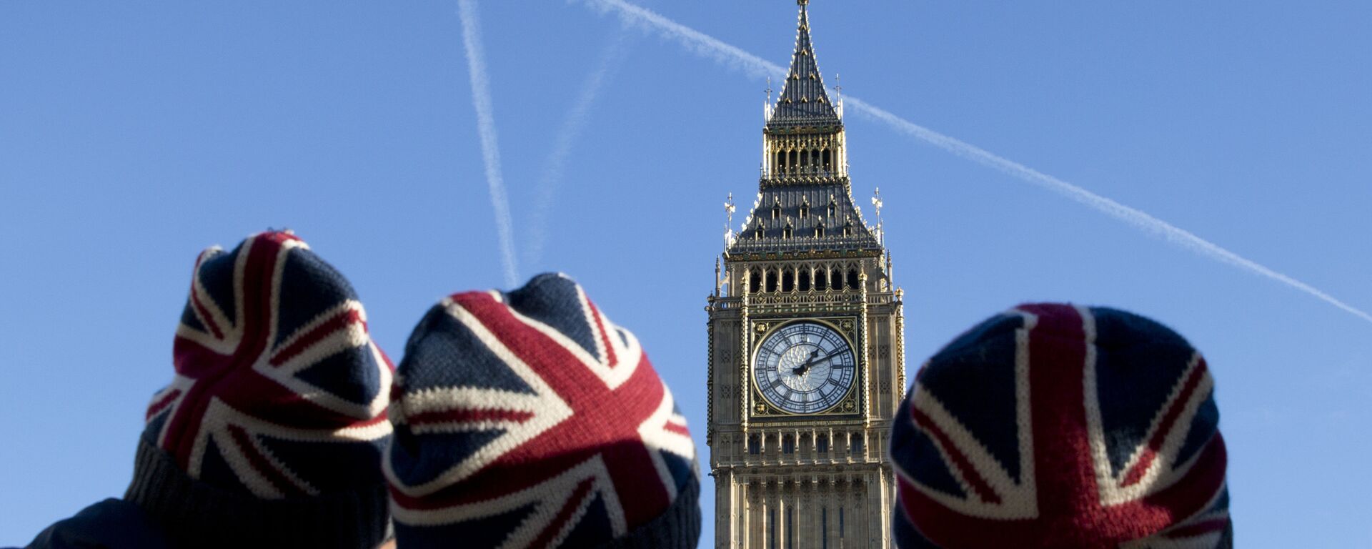 People wear Union flag-themed hats as they look at the Elizabeth Tower, better known as Big Ben, near the Houses of Parliament in London on January 17, 2017.  - Sputnik International, 1920, 19.06.2023