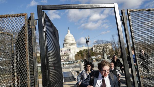People rush through security fencing near the US Capitol ahead of the 2017 Presidential Inauguration. - Sputnik International