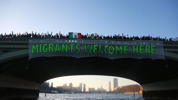 'Migrants Welcome Here' banner hanging over Westminster Bridge, London - Sputnik International
