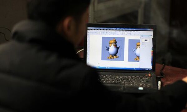 A designer looks at a 3D model of the rooster on a computer - Sputnik International