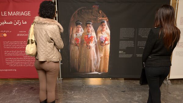 Moroccan women look at photographs of under-age brides during an exhibition by Stephanie Sinclair at the Mohammed V theatre in Rabat on December 4, 2013 - Sputnik International