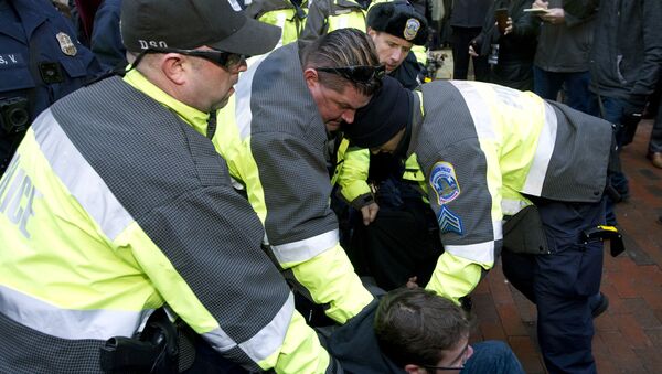 Police try to remove a demonstrator from attempting to block people entering a security checkpoint, Friday, Jan. 20, 2017, ahead of President-elect Donald Trump's inauguration in Washington - Sputnik International
