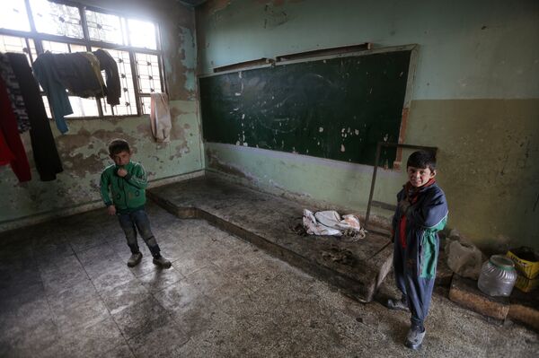 Members of Ahmed al-Abdullah's family stand near a board inside a damaged school, in rebel-held Tal-Aar village, northern Aleppo province, Syria December 28, 2016 Members of Ahmed al-Abdullah's family stand near a board inside a damaged school, in rebel-held Tal-Aar village, northern Aleppo province, Syria December 28, 2016 - Sputnik International