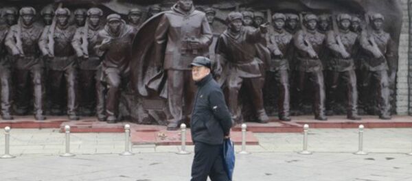 An old man walks in front of a statue of the People's Volunteer Army near the Dandong Broken Bridge Scenic Area - Sputnik International