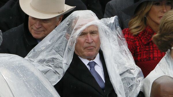 Former president George W. Bush keeps covered in the rain as he sits with his wife Laura at the inauguration ceremonies swearing in Donald Trump as the 45th president of the United States on the West front of the U.S. Capitol in Washington, U.S., January 20, 2017 - Sputnik International