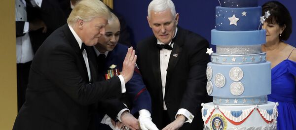 President Donald J. Trump, left, and Vice President Mike Pence, right, are helped by Coast Guard Petty Officer 2nd Class Matthew Babot, center, as they cut a cake at The Salute To Our Armed Services Inaugural Ball Friday, Jan. 20, 2017, in Washington. - Sputnik International