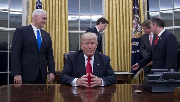 US President Donald Trump (C) waits at his desk before signing confirmations for James Mattis as US Secretary of Defense and John Kelly as US Secretary of Homeland Security, as Vice President Mike Pence (L) and White House Chief of Staff Reince Priebus (R) look on, in the Oval Office of the White House in Washington, DC, January 20, 2017 - Sputnik International
