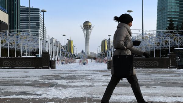 A picture taken on January 22, 2017 shows a woman walking in downtown Astana, with the Baiterek monument seen in the background - Sputnik International