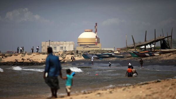 A fisherman and his son stand near the Russian-built Kudankulam Atomic Power Project, at Kudankulam, about 700 kilometers (440 miles) south of Chennai, Tamil Nadu state, India, Thursday, Sept. 13, 2012 - Sputnik International