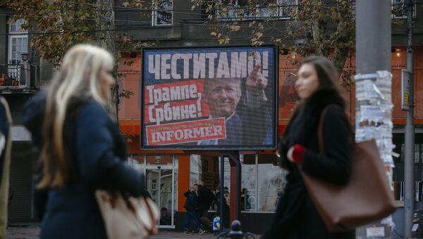 Pedestrians walk by a billboard picturing US President-elect Donald Trump with an inscrpition that translates as Congratulations! Trump, Serb! published by Serbian daily newspaper in Belgrade on November 10, 2016 - Sputnik International