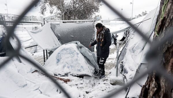A migrant stands next to a snow-covered tent at the Moria hotspot on the island of Lesbos , following heavy snowfalls on January 7, 2017. - Sputnik International