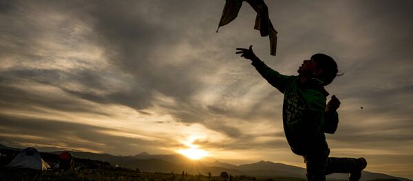 A refugie boy flies his kite at sunset A refugie boy flies his kite at sunset - Sputnik International
