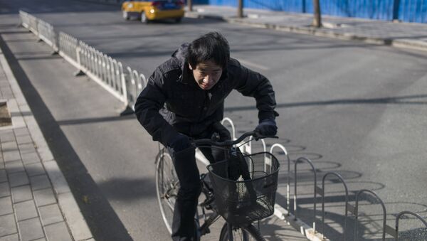 A man rides his bike in the street in Beijing (file) - Sputnik International