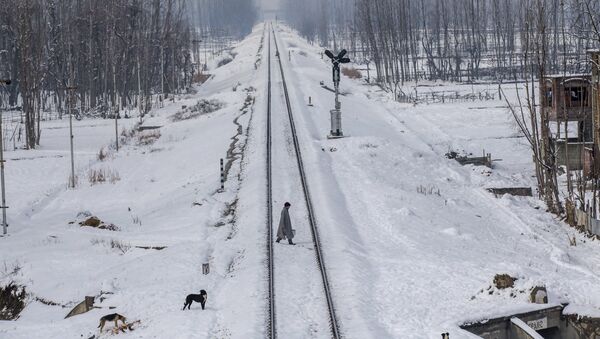 A Kashmiri man crosses snow covered railway track in the outskirts of Srinagar, Indian controlled Kashmir - Sputnik International