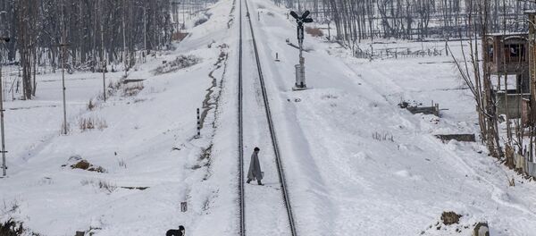 A Kashmiri man crosses snow covered railway track in the outskirts of Srinagar, Indian controlled Kashmir - Sputnik International